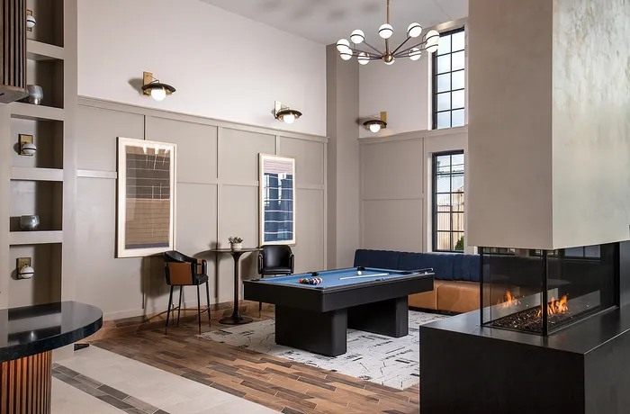 Elegant recreation room featuring a pool table, stylish seating, and a modern fireplace.