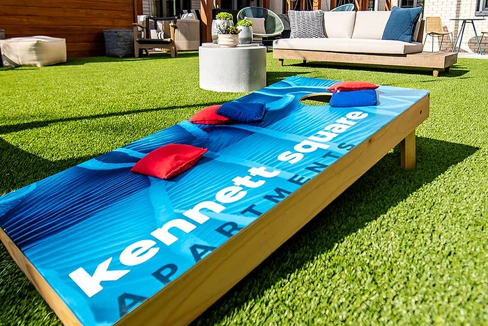 Vibrant outdoor recreation area with a bean bag toss game at Kennett Square Apartments.