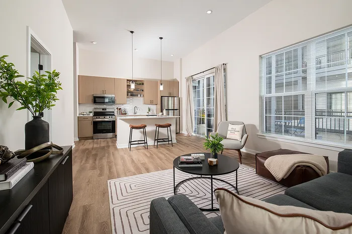 Bright, modern open-concept kitchen and living room with stylish decor and large windows.