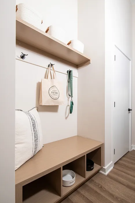 Inviting entryway nook with wooden bench, organized shelf, and stylish storage baskets.