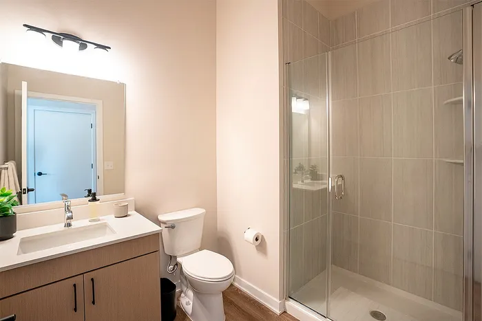 Bright and modern bathroom featuring a glass-enclosed shower and stylish vanity.