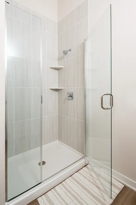 Sleek glass-enclosed shower with modern tilework and chrome fixtures.