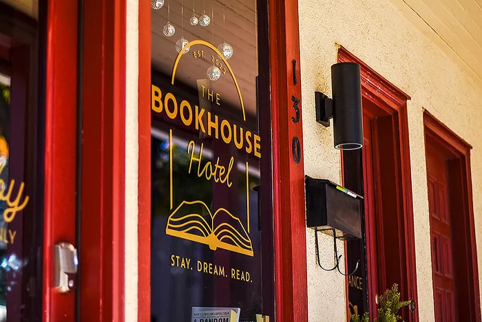 Charming entrance of The Bookhouse Hotel featuring a welcoming red door and elegant signage.