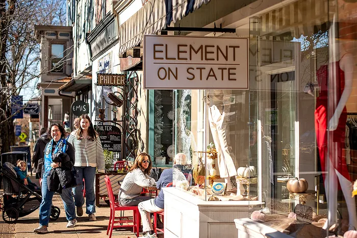 Vibrant city street featuring cozy cafes, boutique shops, and pedestrians enjoying the day.