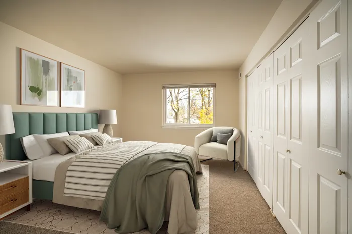 Inviting bedroom with a stylish green headboard, cozy chair by the window, and ample closet space.
