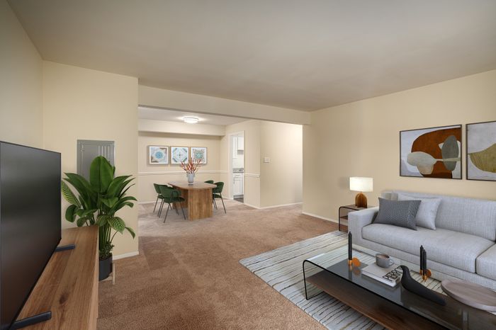 Stylish living room with modern decor, featuring a sleek gray sofa, a wooden coffee table, and contemporary wall art.