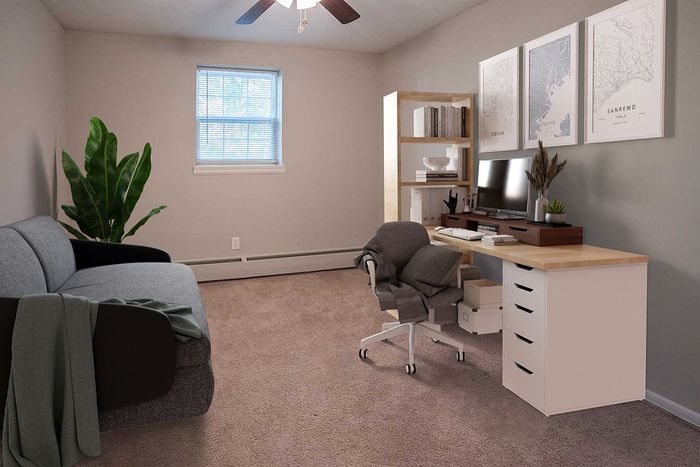 Modern home office with stylish desk, computer, and comfortable seating.