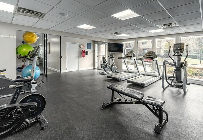 Well-equipped gym with exercise bikes, treadmills, and panoramic windows.