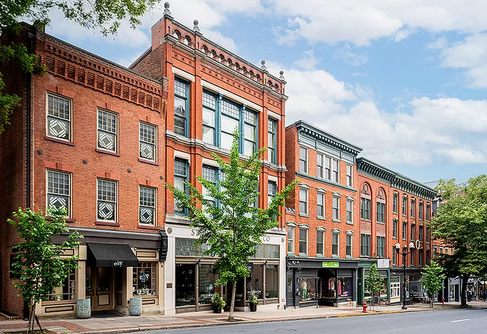 Vibrant street view of classic brick buildings with large windows and charming storefronts.