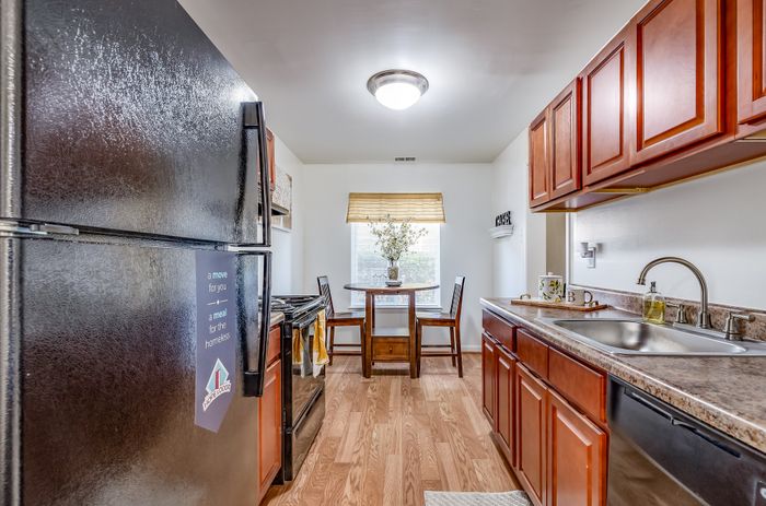 Inviting kitchen with warm wooden cabinetry, modern appliances, and a charming dining nook.
