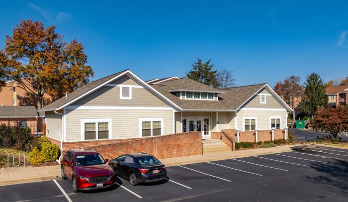 Charming residential building with a modern design and well-kept parking area surrounded by vibrant autumn trees.