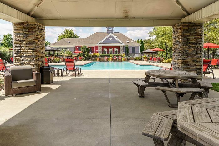Inviting swimming pool area with modern outdoor seating and lush landscaping.