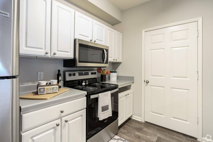 Contemporary kitchen with white cabinetry, stainless steel appliances, and elegant countertops.