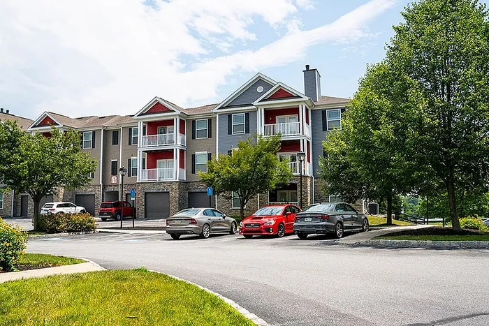 Inviting apartment complex with modern design, balconies, and surrounding greenery.