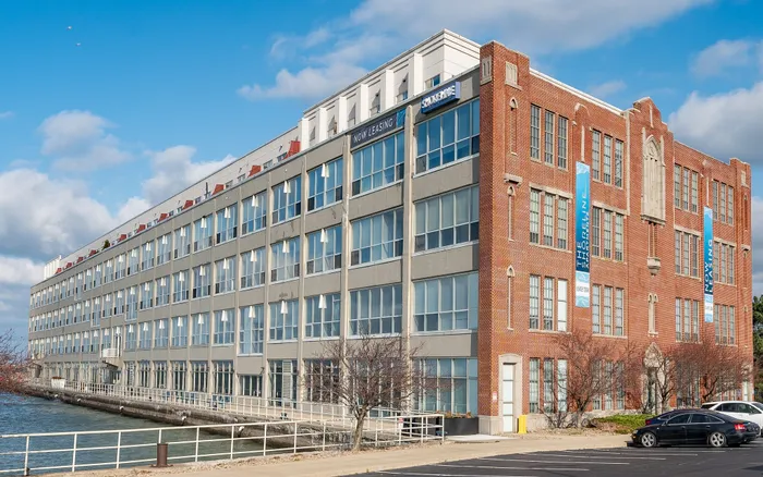 Charming waterfront apartment building with modern design and large windows, offering scenic views and contemporary living spaces.