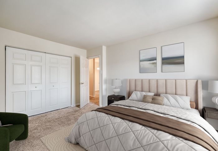 Bright and inviting bedroom with modern decor, featuring a plush bed, cozy carpet, and stylish artwork on the wall.