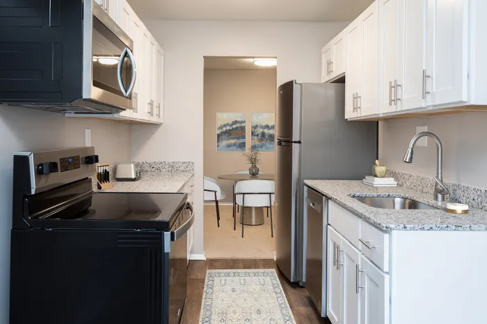 Modern kitchen with stainless steel appliances and granite countertops.
