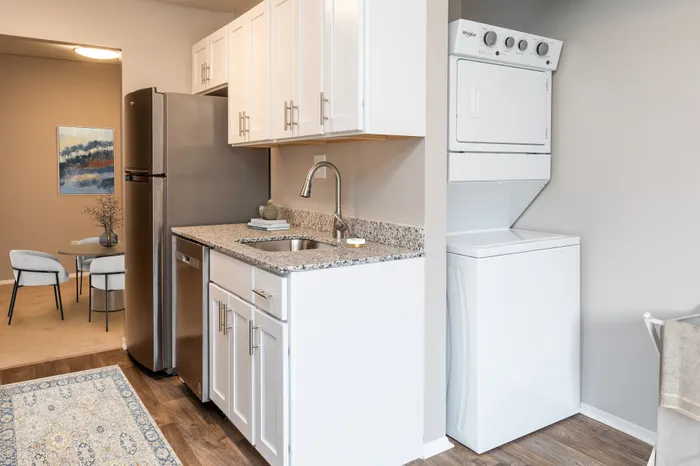 Modern kitchen with granite countertops, stainless steel appliances, and in-unit laundry.