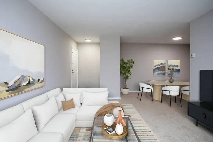 Modern living room with elegant white sectional sofa and dining area.