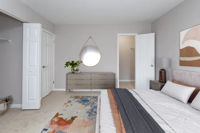 Inviting bedroom with modern decor, cozy bed, and elegant dresser.
