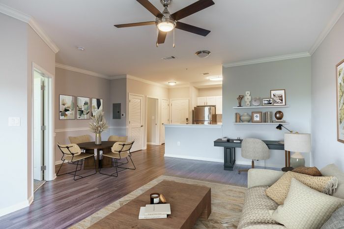 Chic open-plan living area with elegant dining space, stylish decor, and a modern kitchen, featuring light wood flooring and cozy furnishings.
