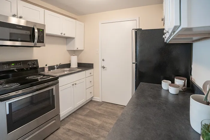Modern kitchen with sleek stainless steel appliances, elegant white cabinetry, and spacious countertops for a contemporary living experience.