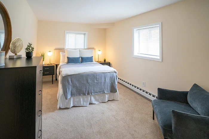 Inviting bedroom with abundant natural light, a cozy bed, and elegant decor in a warm-toned apartment.
