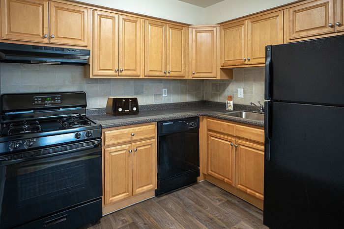 Inviting kitchen with warm wooden cabinets, modern appliances, and sleek countertops.