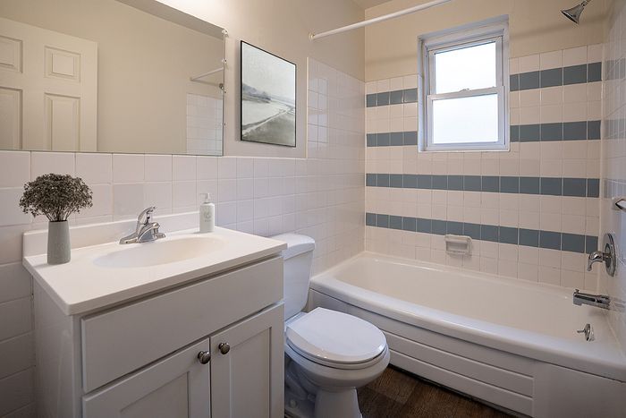 Inviting bathroom featuring a sleek vanity, modern fixtures, and a bathtub with stylish tile accents.