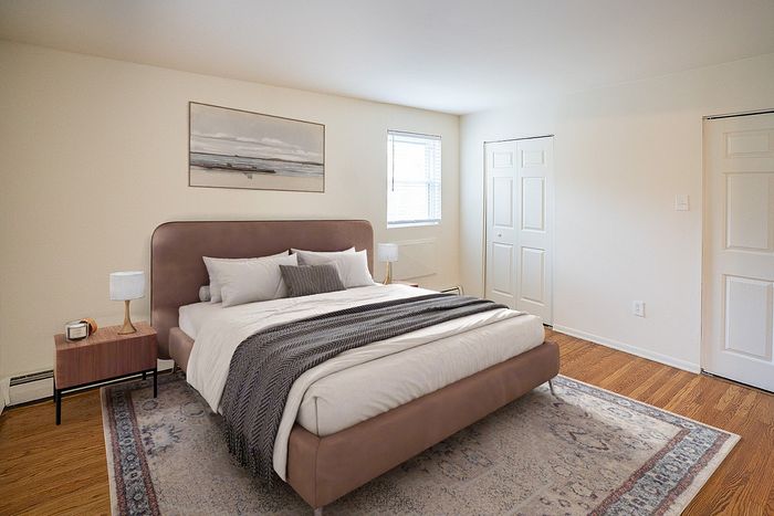 Bright and inviting bedroom featuring a plush king-sized bed, elegant decor, and natural light through large window.