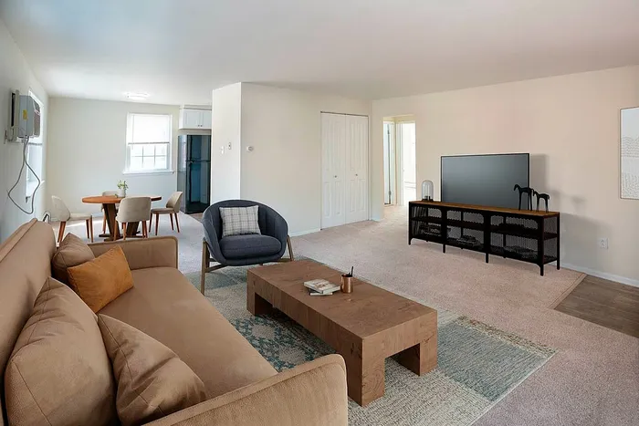 Inviting and spacious living area with modern furniture, cozy seating, and ample natural light streaming through large windows.