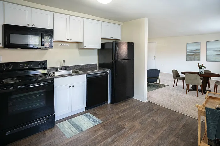 Modern apartment with sleek kitchen, hardwood floors, and a cozy dining area filled with natural light.