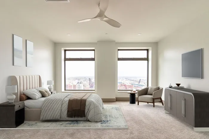 Luxurious bedroom with modern decor, featuring large windows with breathtaking city views, cozy seating area, and elegant furnishings.