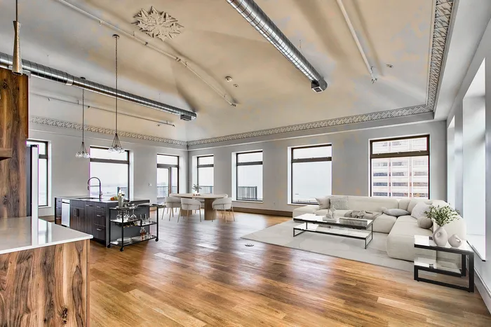 Luxurious open-concept living and dining area with modern finishes, large windows, and elegant wood flooring.