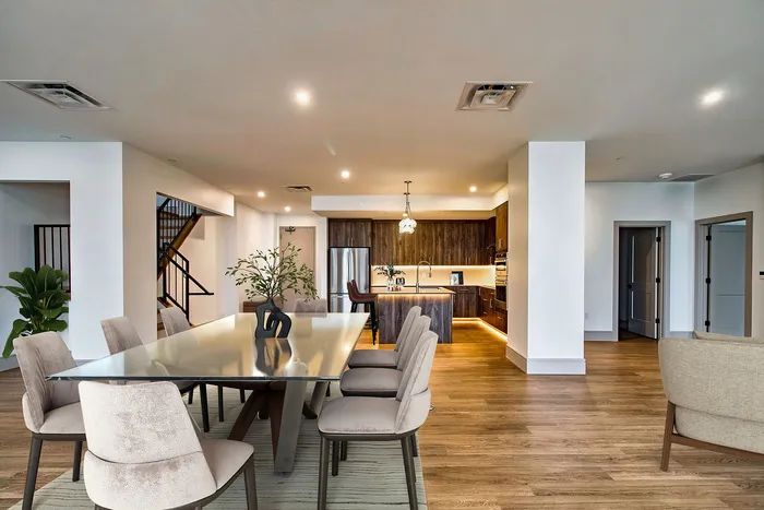 Luxurious open-plan dining and kitchen area with modern accents, featuring elegant lighting and sophisticated decor.