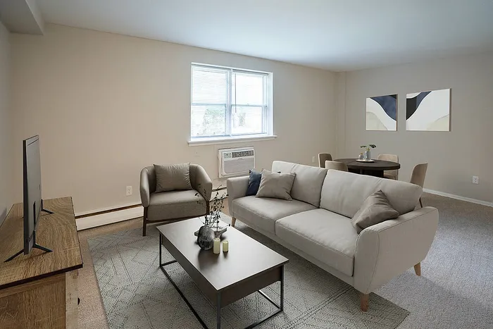 Contemporary living room with a cozy sofa, stylish coffee table, and modern decor, illuminated by natural light through large windows.