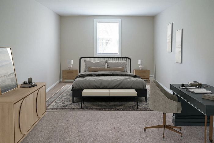 Elegant bedroom with plush carpet, stylish gray bedding, and modern furniture, including a sleek desk and cozy chair.