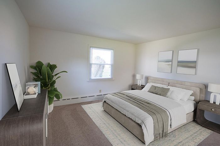 Bright and inviting bedroom with a plush bed, elegant decor, and a large window for natural light.