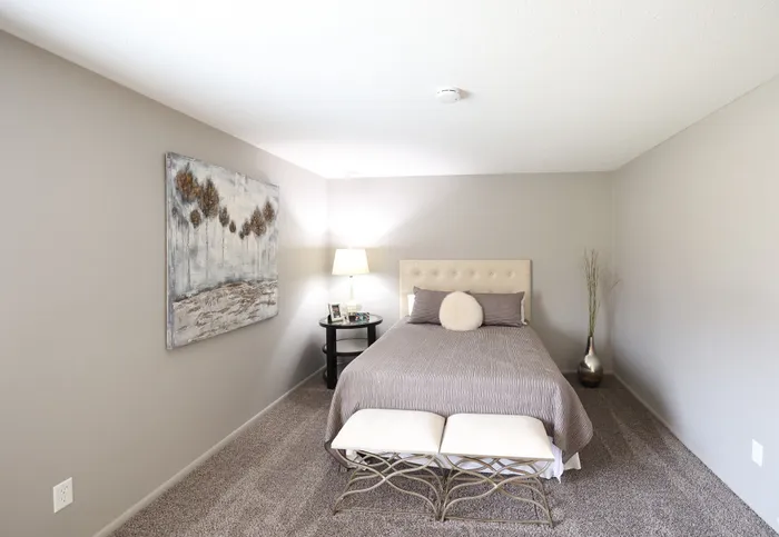 Chic bedroom with a plush bed, elegant decor, modern artwork, and cozy ambiance.