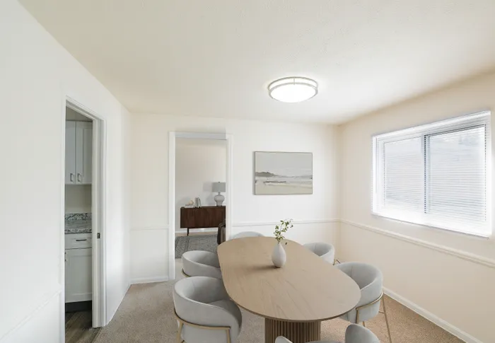 Bright dining area with elegant table and modern chairs, featuring a large window for natural light and a stylish minimalist decor.
