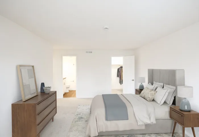 Bright and inviting bedroom with cozy king-sized bed, stylish dresser, and modern decor, featuring a spacious walk-in closet and en-suite bathroom.