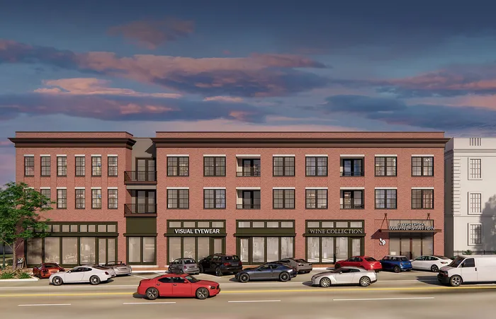 Charming urban building with classic red brick facade, featuring boutique shops like Visual Eyewear and Wine Collection, under a serene evening sky.