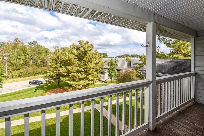 Charming balcony view overlooking lush greenery and quaint neighborhood, perfect for peaceful afternoons.