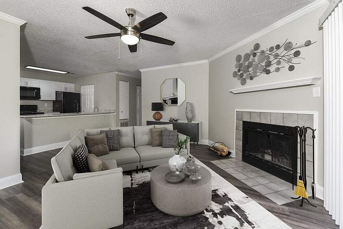 Modern living room featuring a sleek corner fireplace, elegant decor, and an inviting open-plan layout with kitchen view.