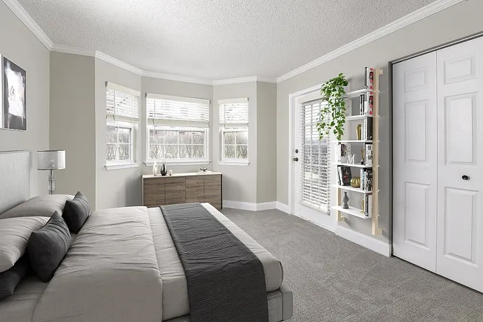 Bright and inviting bedroom with plush carpeting, large windows, and chic decor, featuring a modern bed and stylish shelving.