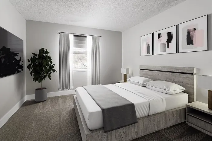 Elegant bedroom featuring modern decor with a cozy bed, abstract art, lush potted plant, and ample natural light through a large window.