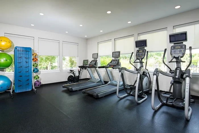 Modern gym facility with state-of-the-art cardio machines and vibrant exercise balls, offering a bright and inviting workout space.