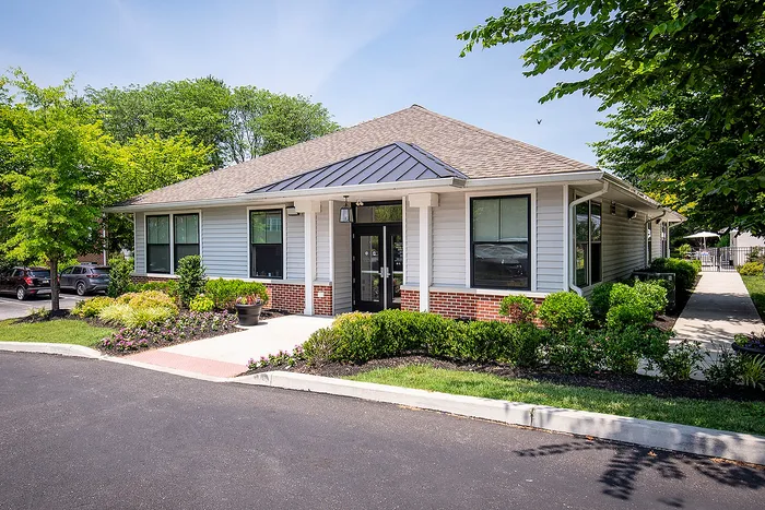 Charming single-story home with modern design, surrounded by lush greenery and vibrant landscaping, offering a serene and inviting atmosphere.
