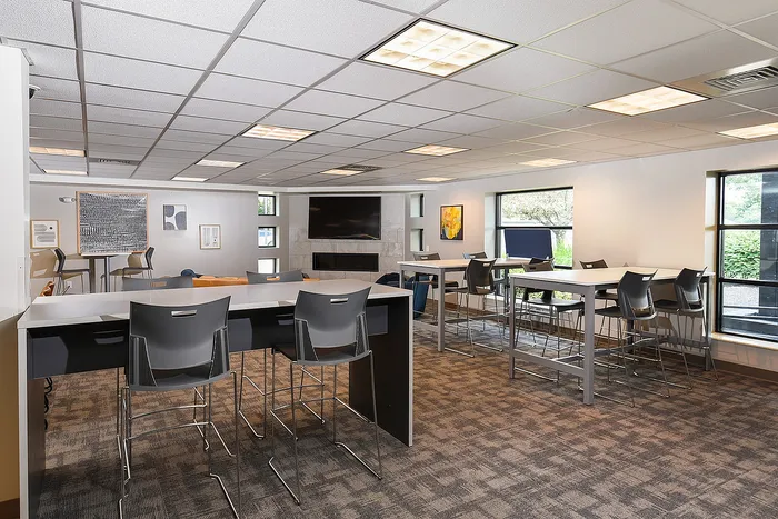 Chic and spacious community lounge with modern seating, ample natural light, and vibrant decor ideal for social gatherings.
