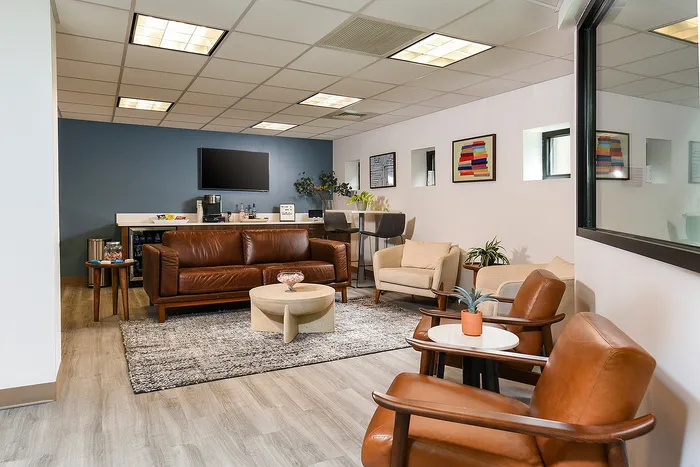 Chic modern lounge with leather seating, stylish decor, and a sleek entertainment area.